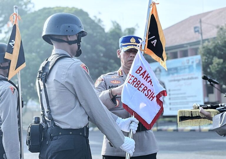 Jumbai Kebersihan Barak Upaya SPN Polda Jatim Tanamkan Disiplin dan Tanggung Jawab Siswa Diktuba PolriMOJOKERTO – Lapangan Catur Prasetya di Sekolah Polisi Negara (SPN) Polda Jawa Timur menjadi saksi bisu penegakan disiplin dan pembinaan karakter bagi 247 Siswa Pendidikan Pembentukan Bintara (Diktukba) Polri Gelombang II T.A. 2025.  Pada Senin (6/10/2025) pagi, di bawah langit yang cerah, para siswa mengikuti Upacara Bendera Pola Pengasuhan yang dirangkai dengan penganugerahan jumbai (bendera) lomba kebersihan barak.  Upacara yang berlangsung khidmat tersebut dipimpin langsung oleh Kepala SPN Polda Jatim, Komisaris Besar Polisi (Kombes Pol) Agus Wibowo, S.I.K. Turut hadir dalam upacara seluruh Perangkat Pengasuh Siswa Diktukba, yang konsisten mendampingi dan membentuk calon Bhayangkara negara tersebut.  Puncak acara yang dinanti-nantikan adalah pengumuman hasil lomba kebersihan antar barak.  Sebuah kompetisi yang tidak hanya mengukur kerapian fisik lingkungan barak, tetapi juga mencerminkan kekompakan, tanggung jawab, dan kedisiplinan para siswa dalam lingkungan terkecil mereka.  Hasilnya, Barak H yang dihuni oleh Pleton 1 Kompi A berhasil meraih predikat tertinggi dan berhak menerima “Jumbai Kebersihan”.  Bendera kehormatan ini menjadi simbol prestasi atas kerja keras dan soliditas mereka dalam menjaga standar kerapian dan ketertiban.  Sementara itu, “Jumbai Tengkorak”, simbol evaluasi untuk barak dengan nilai terendah, diserahkan kepada Barak K yang ditempati oleh Pleton II dan III Kompi C.  Kepala SPN Polda Jatim, Kombes Pol Agus Wibowo mengatakan penganugerahan ini bukan bertujuan untuk mempermalukan, melainkan sebagai pemacu semangat dan pengingat konstruktif untuk segera berbenah serta meningkatkan kualitas disiplin.  Kombes Pol Agus Wibowo juga menegaskan bahwa kebersihan dan kerapian adalah cerminan dari kepribadian seorang abdi negara.  “Disiplin yang tertanam dari hal-hal kecil akan menjadi fondasi kokoh dalam menghadapi tugas-tugas besar di masa depan,” ungkap Kombes Agus.  Ia menyebut kompetisi kebersihan barak ini adalah miniatur dari tugas kepolisian sesungguhnya.  “Ada standar yang harus dicapai, ada kerja sama tim yang diuji, dan ada evaluasi untuk perbaikan berkelanjutan,” ujar Kombes Pol Agus Wibowo.  Masih kata Kombes Agus, kegiatan ini merupakan bagian integral dari Pola Pengasuhan yang diterapkan di SPN Polda Jatim, di mana setiap aspek kehidupan siswa, mulai dari bangun tidur hingga kembali beristirahat, menjadi wahana pembelajaran untuk membentuk postur Polri yang presisi, humanis, dan berintegritas.
